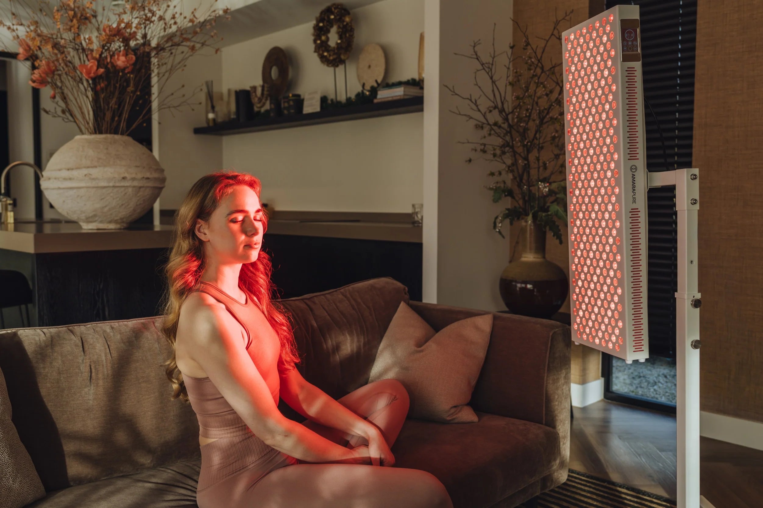 Vrouw mediteert thuis voor een AmaraPure roodlichtpaneel
